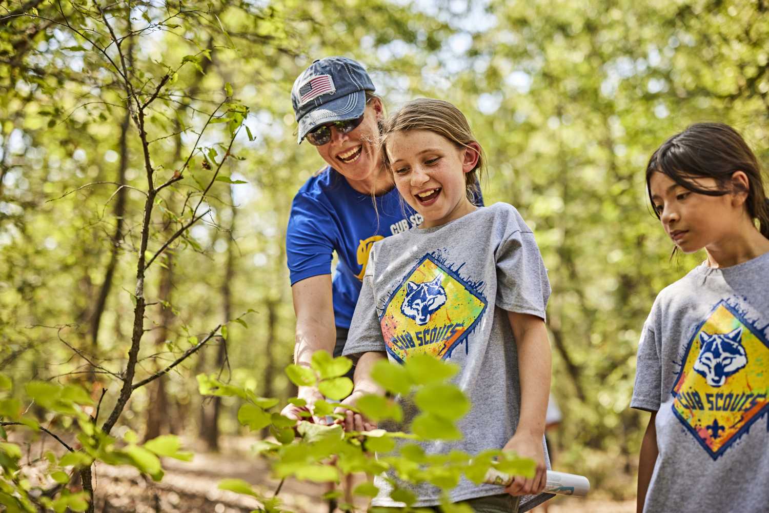 A young girl and an older woman study a plant together happily